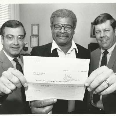 Photograph by Jeff Weissman. Accepting check from David Seeley (Acute Care Affiliates) and John E. Martin (Herrick Hospital), 10/22/1985.: 2011.060.336k