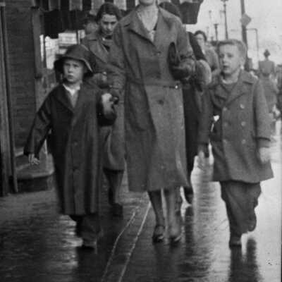 Mother and boys walking on street