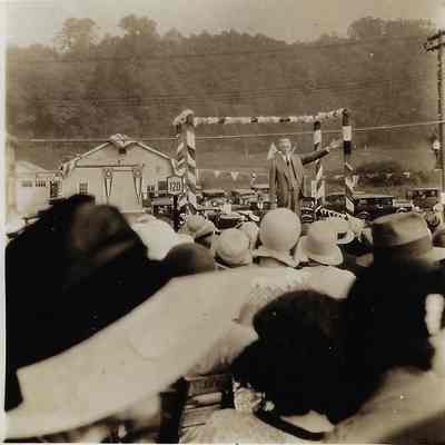 Man on Platform Addressing a Crowd