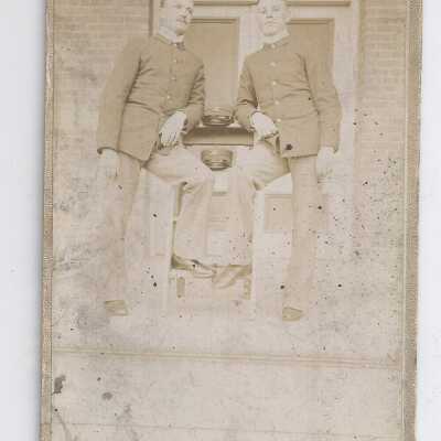 Two soldiers leaning on table.
