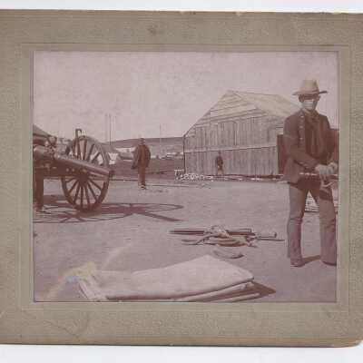 Three men near a cannon