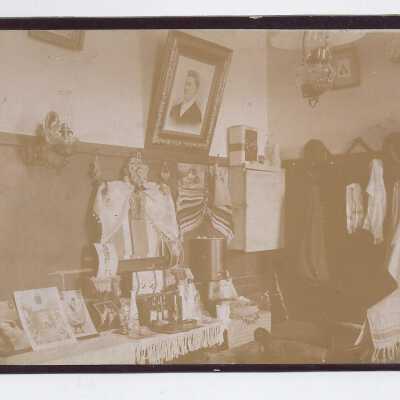 Room with pictures and clothes on hooks.