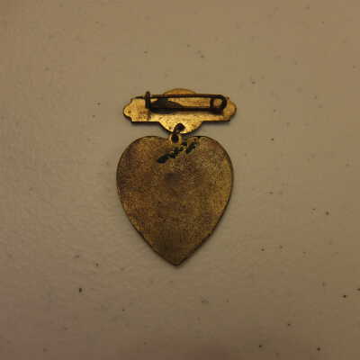 In Memory banner and heart-shaped brass pin.