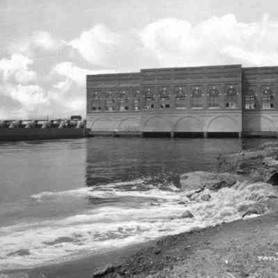 An exterior shot of the dam taken from downstream. From the late 1940s or early 1950s, based on the long wingwall downstream of the plant. That wall does not exist anymore.