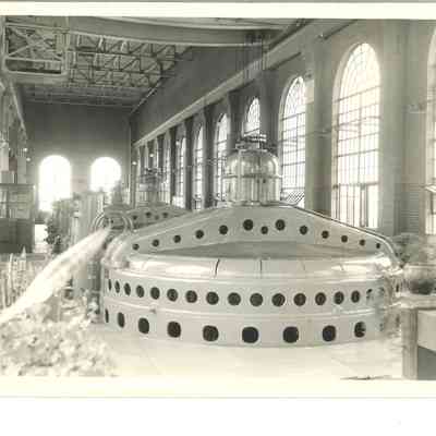 A photo from inside the dam powerhouse, showing 6 vertical generating units. Estimated to be 1943.
