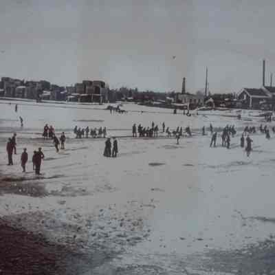 John Week Lumber Company, East side of Wisconsin River. Ice skaters in foreground. Circa 1910