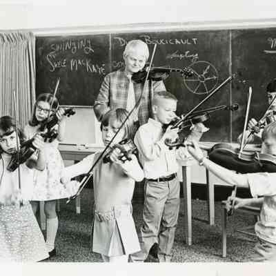 Margery Aber teaches students the violin