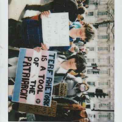 A group of people are holding protest signs, one says "TERF RHETORIC IS A TOOL FOR THE PATRIARCHY".