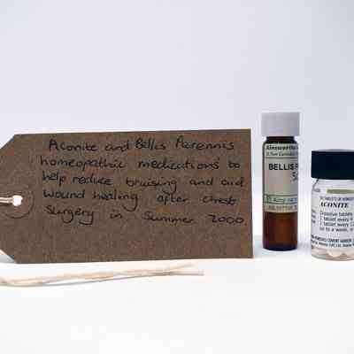 The image shows two homeopathic medication bottles and a handwritten label detailing their intended use.