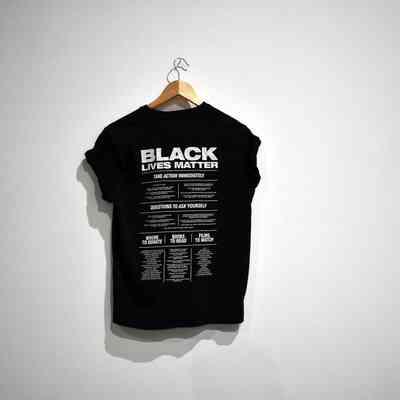 Hanging on a wall, a black T-shirt displays a "Black Lives Matter" message in bold text.