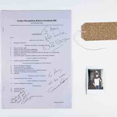 A copy of the Gender Recognition Reform (Scotland) Bill, signed by Nicola Sturgeon, Shona Robinson and Joe. With a polaroid of the donor and a brown handwritten luggage tag.