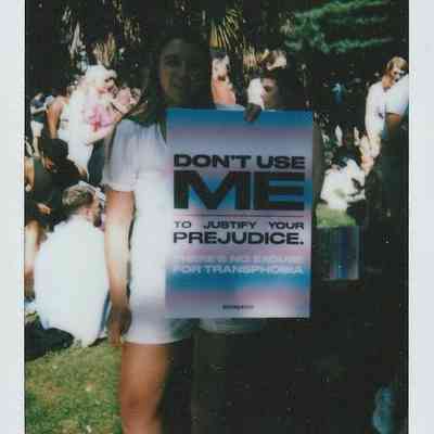 A person is holding a sign which says "DON'T USE ME TO JUSTIFY YOUR PREJUDICE".