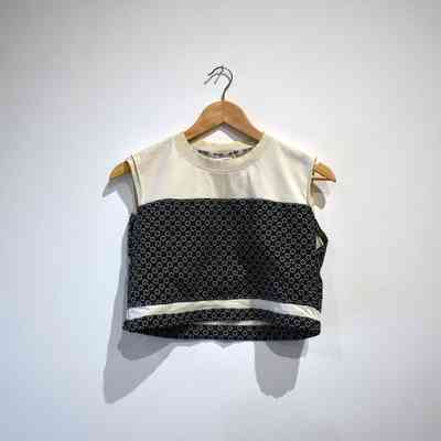 A handmade binder made from a cream shirt with a dark blue, floral patterned, material. On a wooden hanger.