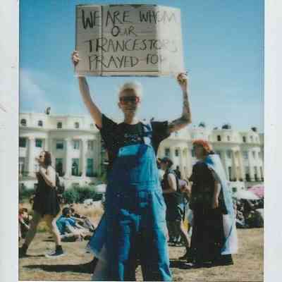 A person proudly holds a sign reading, "We are whom our ancestors prayed for".