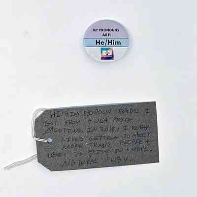 A "He/Him" pronoun badge from a 2018 pride meeting with a brown tag.