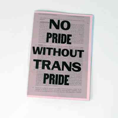 A zine on a white surface states, "No Pride Without Trans Pride," in bold letters.