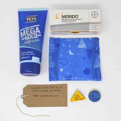 The image shows a styling gel, medication box, sanitary pad, badges, and a handwritten tag.