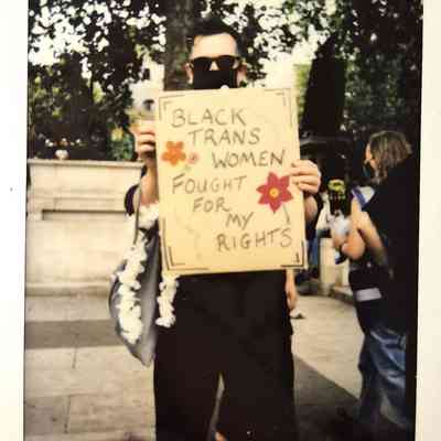 A person holds a sign reading "Black trans women fought for my rights" at a protest.