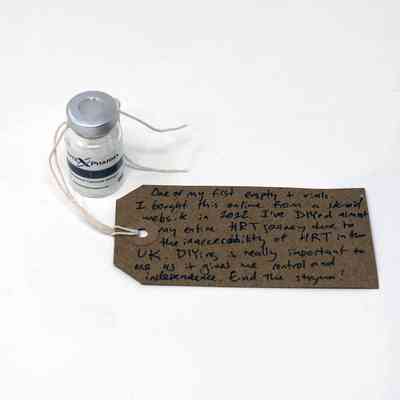 A bottle of testosterone vial. Next to it is a brown tag with writing on it.