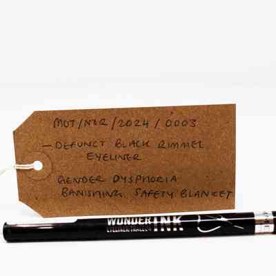 A brown tag labeled "defunct black Rimmel eyeliner" sits beside the eyeliner pen.