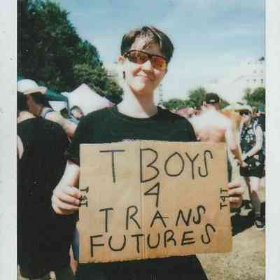 A person is holding a sign that reads "T Boys 4 Trans Futures" at Trans Pride Brighton.