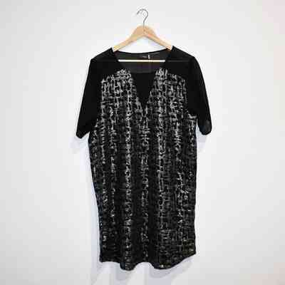 Black and sliver dress on a wooden hanger.