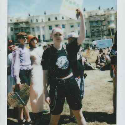 A person stands holding a sign up in the air. It is too blurry to make out what it says.