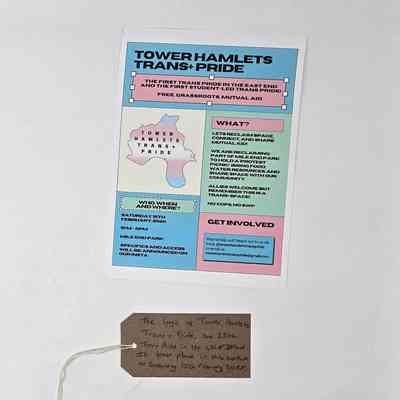 A blue, pink and green flyer advertising Tower Hamlets Trans+ Pride. It details information, dates and how people can get involved. With a brown, handwritten luggage tag.