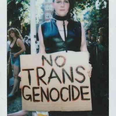 A person holds a "No Trans Genocide" sign at London Trans Pride, Soho, 2022.