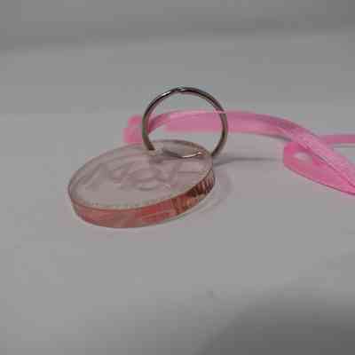 Perspex clear pink circular disc keyring 40mm diameter hanging on metal split ring 25mm diam. With narrow pink ribbon attached approx.. 400mm length. Excellent condition. Disc inscription reads " MoT…to remain collected under all circumstances….Museum of Transology"