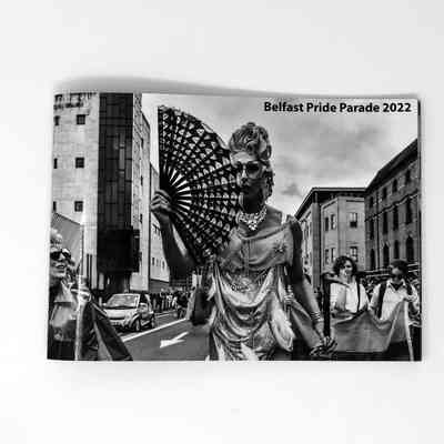 Black and white booklet with person on front holding a fan. "Belfast Pride Parade 2022"