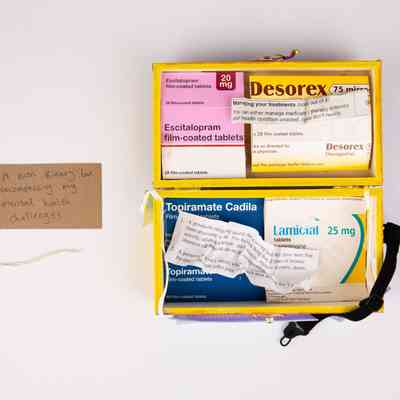 The image shows a yellow box containing medication boxes with a tag reading, "A non-binary box..."