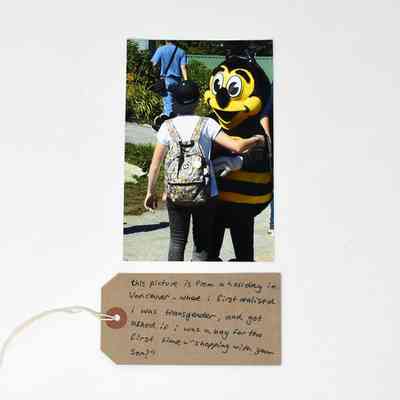 Photograph A6 size; picture of person in baseball hat & man in bee costume.