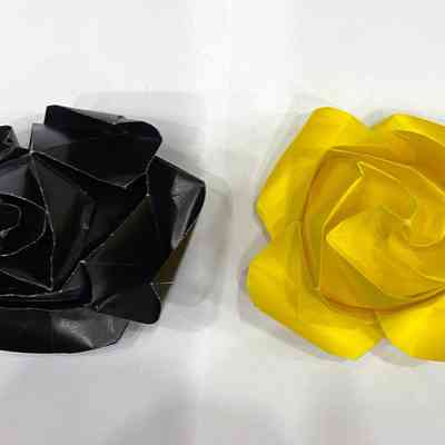 Two handmade origami roses. One black, one yellow.