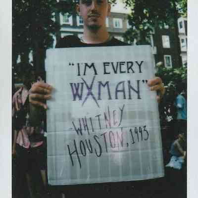 A person holds a sign quoting Whitney Houston's 1993 hit but a slightly different take "I'm Every WXMAN".