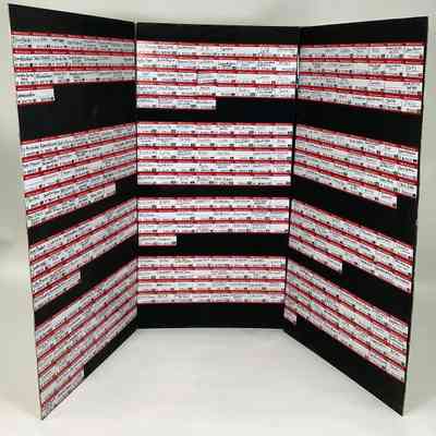 A mural for Transgender Day of Remembrance 2023 entitled "Hello, My Name Was ...". It is a three sided black display stand covered with 392 red and white name badges. Each name badge has a name from the TDoR Remembering Our Dead website.