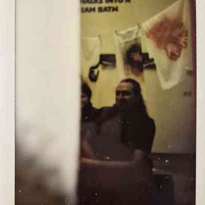 The image shows a partially obscured dimly lit scene with people sitting.