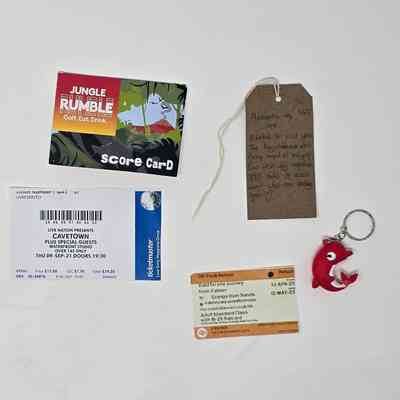 A score card for golf, a gig ticket, for Cavetown, a train ticket, a red dolphin keyring and a brown luggage tag.