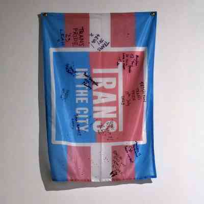 Trans in the City flag, in the trans pride colours. It has been signed by several people.