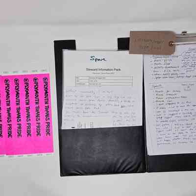 The image displays a steward information pack for Plymouth Trans Pride event, including wristbands and handwritten notes.