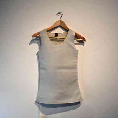 White full-length binder with black bobbles visible on the neck and shoulder seams.