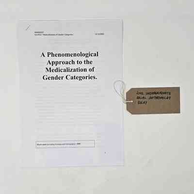 A printed copy of an undergraduate Social Anthropology essay titled "A Phenomenological Approach to the Medicalization of Gender Categories. With a brown handwritten luggage tag.