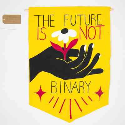 A yellow banner featuring a black hand cupping a white flower with a red stem and the text "THE FUTURE IS NOT BINARY". With a brown, handwritten luggage tag.