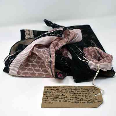 A tichel is displayed with a handwritten tag containing a reflective and personal message.