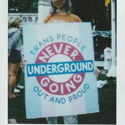 A person holds a sign that reads "Trans People Never Going Underground Out and Proud".