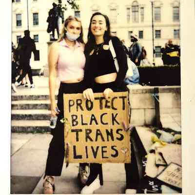 Two people stand together holding a sign that reads "Protect Black Trans Lives," at a demonstration in London,
