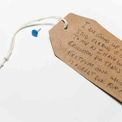 Blue stud earring attached to tag. Blue plain circular stud earring.