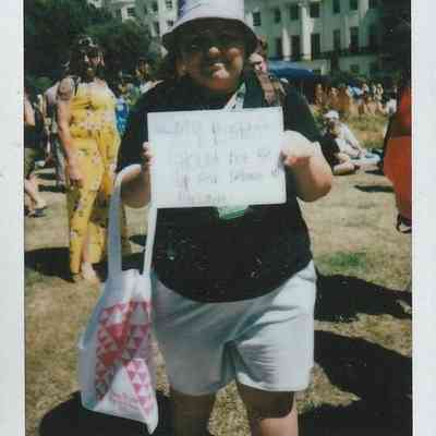 A person holds a sign saying "My rights should not be up for debate".