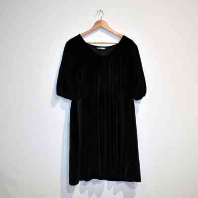 A black dress on a wooden hanger.