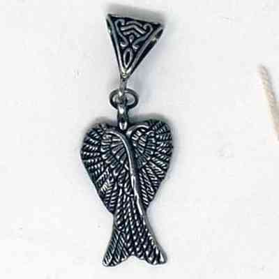 A silver pendant which is next to a brown tag with writing on it.